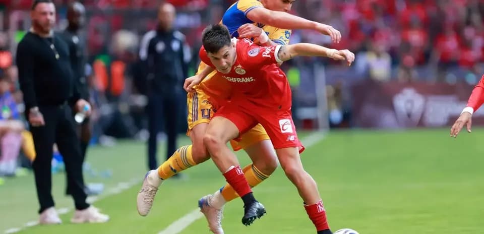 Jugadores de Toluca y Tigres luchando por el balón