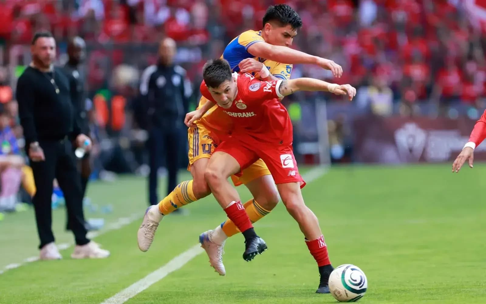 Jugadores de Toluca y Tigres luchando por el balón