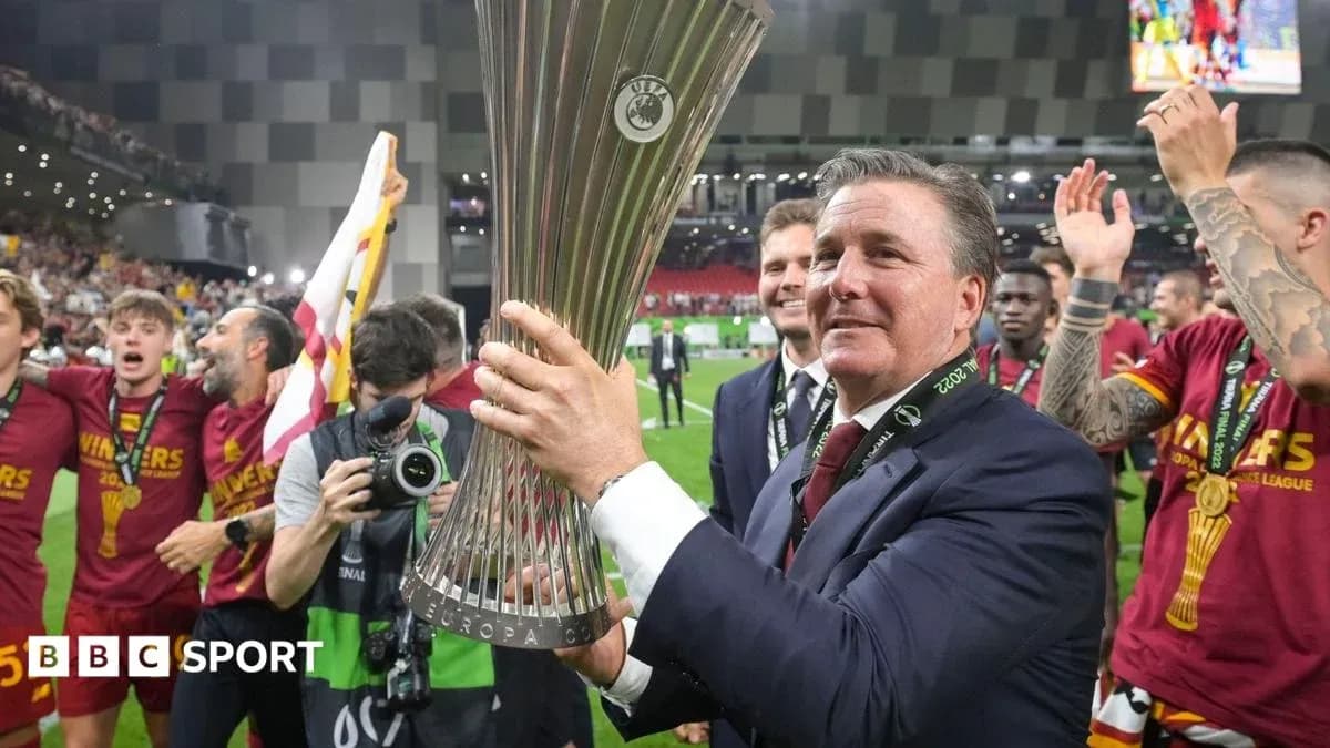 Entrenador sosteniendo trofeo de la Europa League
