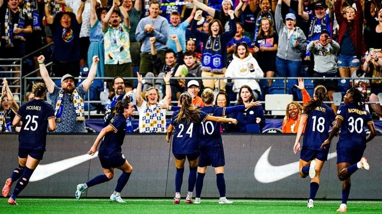 Jugadoras celebrando un gol con aficionados