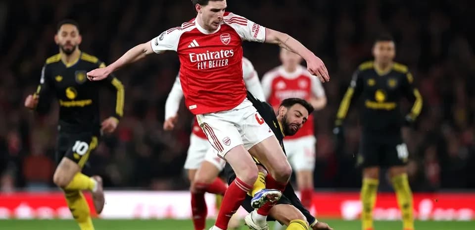 Jugador de Arsenal evita a oponente en el suelo