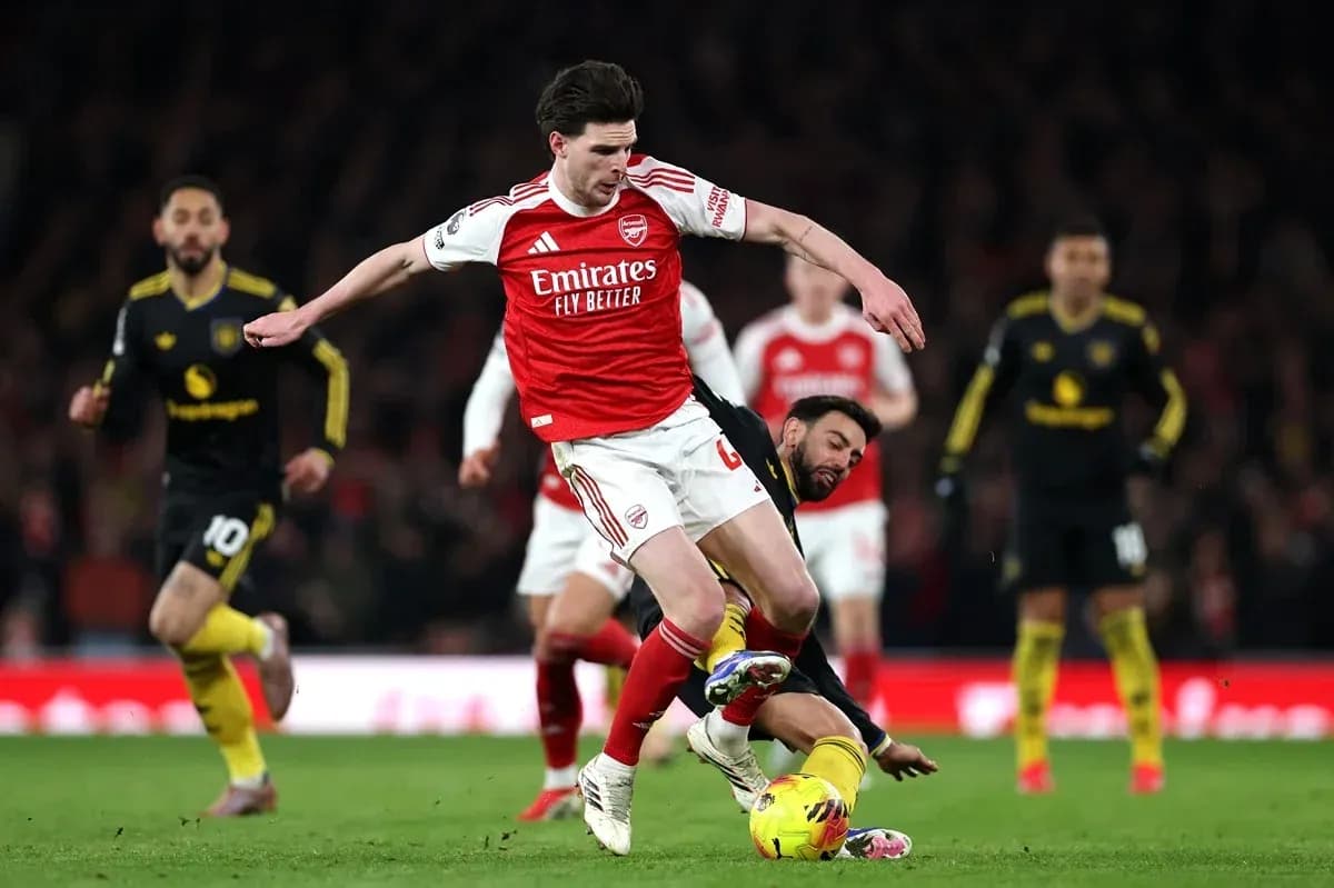Jugador de Arsenal evita a oponente en el suelo