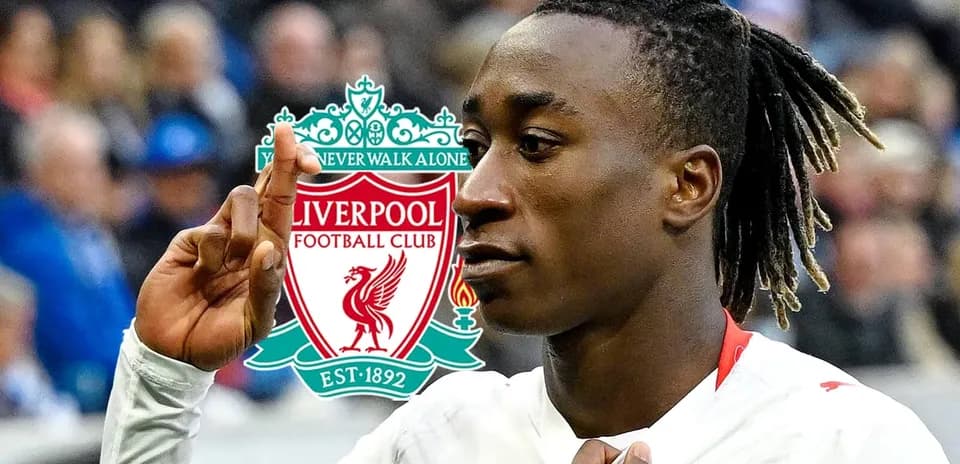 Jugador de fútbol señalando logo de Liverpool FC