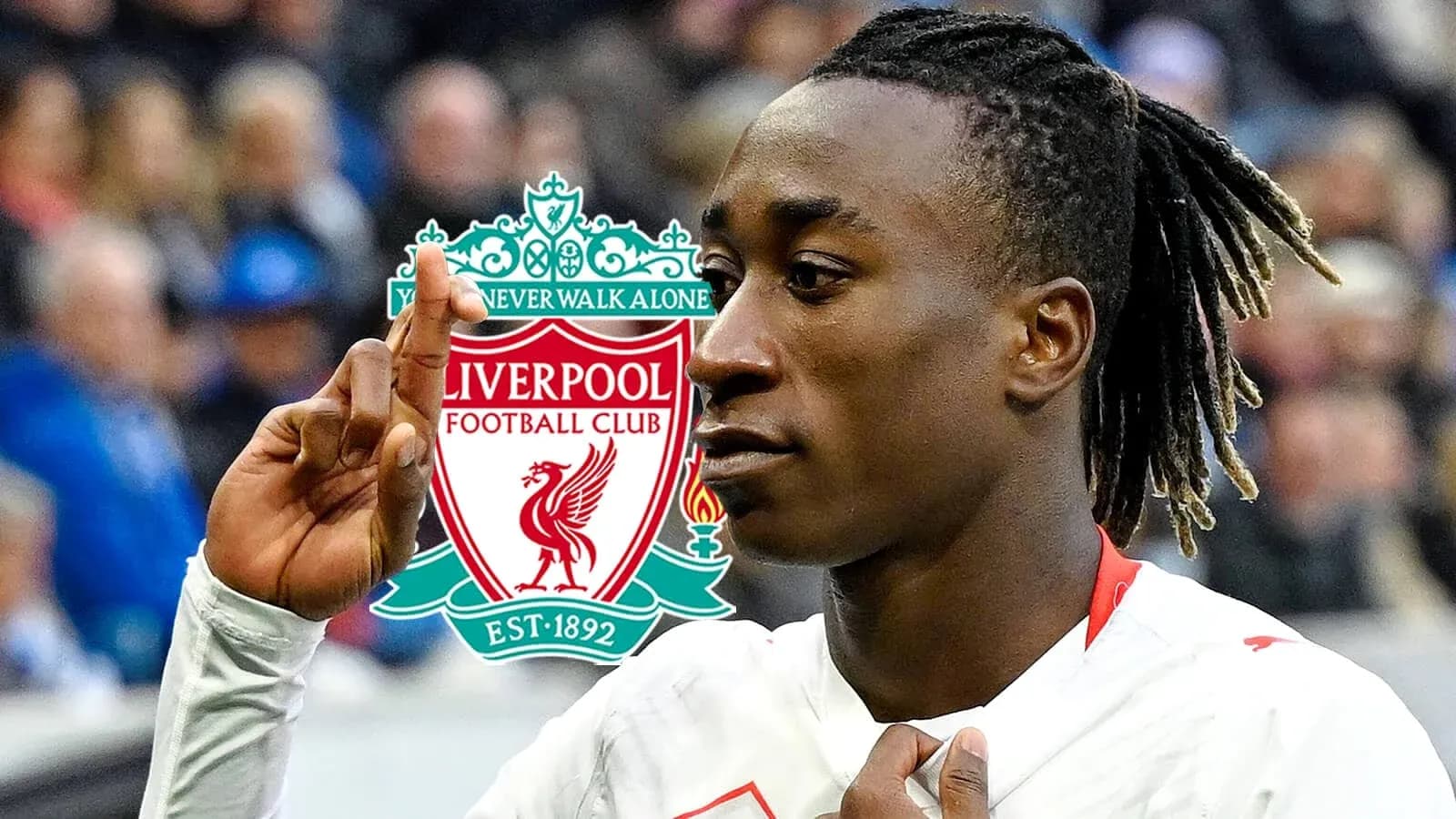 Jugador de fútbol señalando logo de Liverpool FC