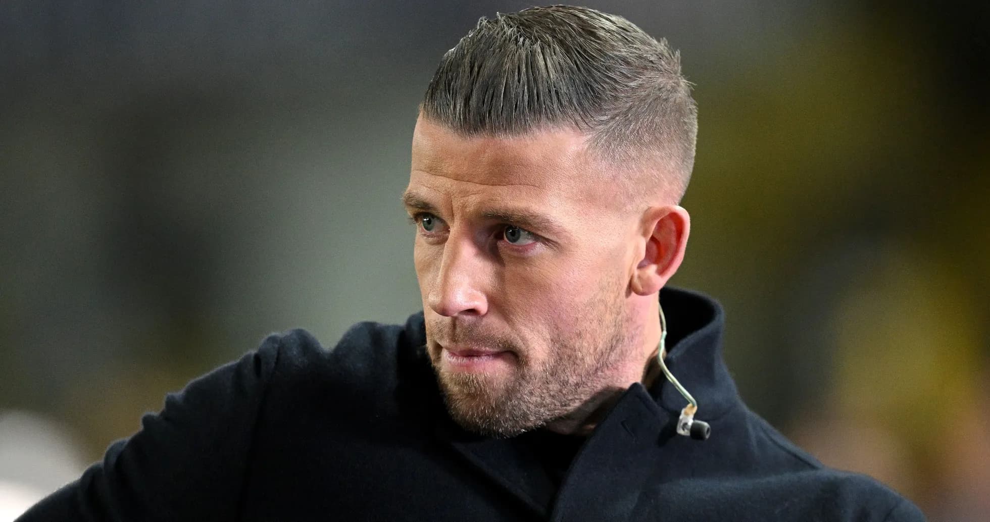 Hombre con abrigo oscuro y peinado corto