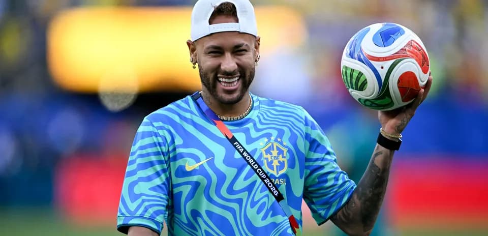 Jugador sosteniendo un balón de fútbol en el campo