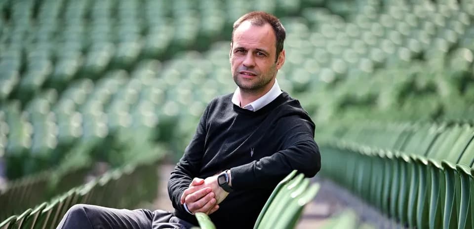 Hombre sentado en gradas vacías de estadio