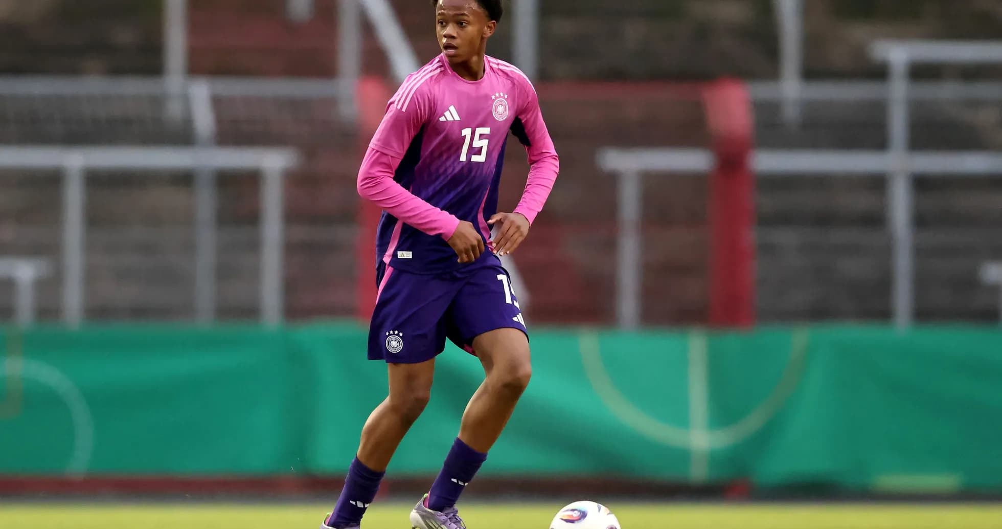 Jugador entrenando con camiseta rosa en el campo