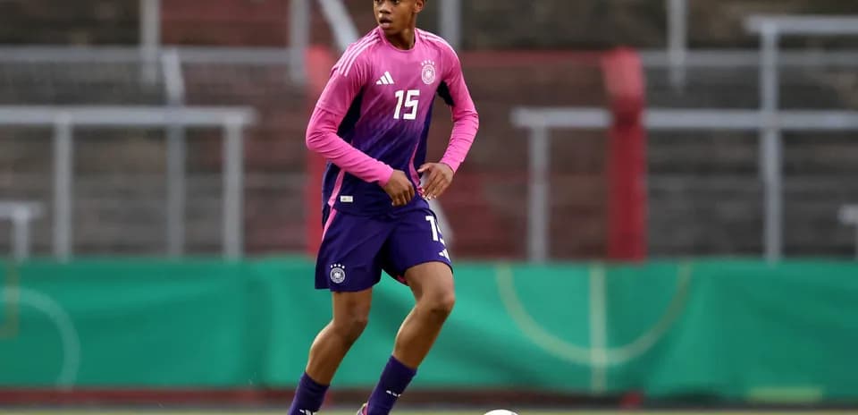 Jugador entrenando con camiseta rosa en el campo