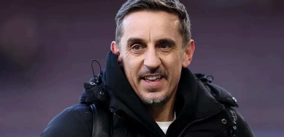 Hombre sonriendo con abrigo en estadio de fútbol