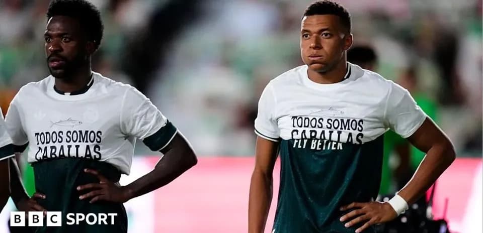 Dos jugadores con camisetas de calentamiento en el campo