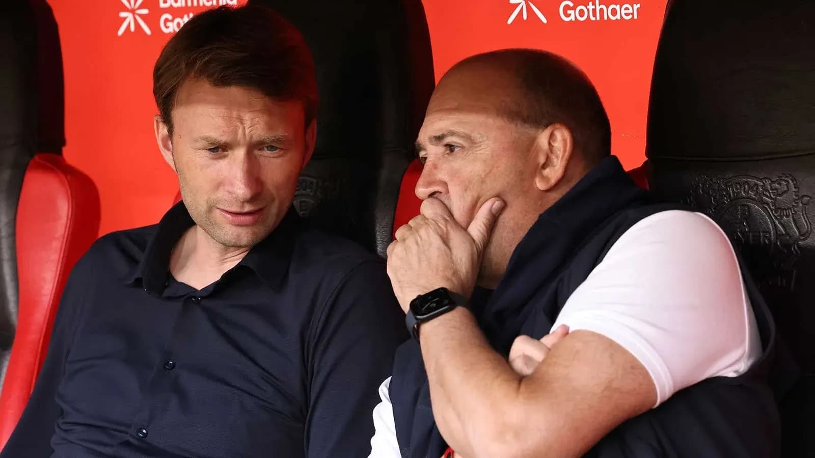 Entrenadores conversando en el banquillo del estadio