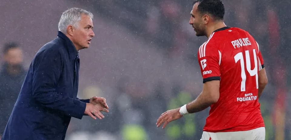 Entrenador hablando con jugador en lluvia durante partido