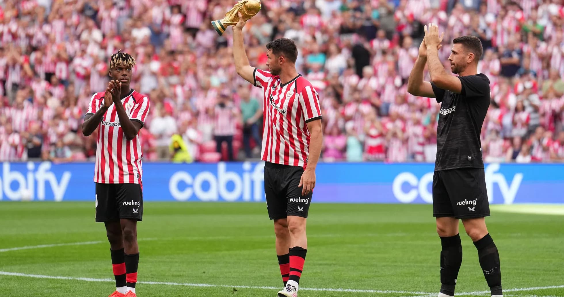 Jugadores de Athletic Club celebrando con trofeo en el campo