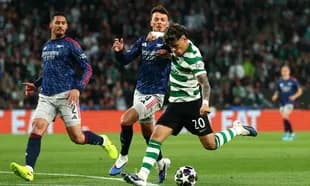 Jugador de Sporting disparando mientras es defendido