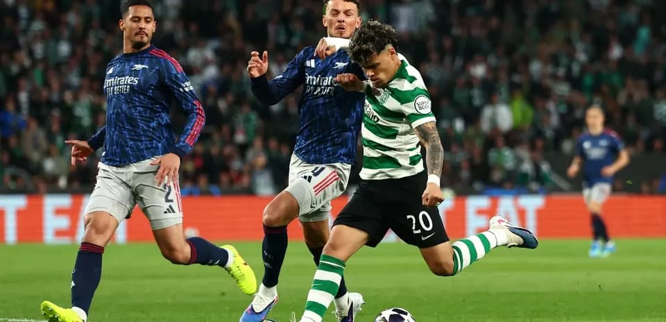 Jugador de Sporting disparando mientras es defendido