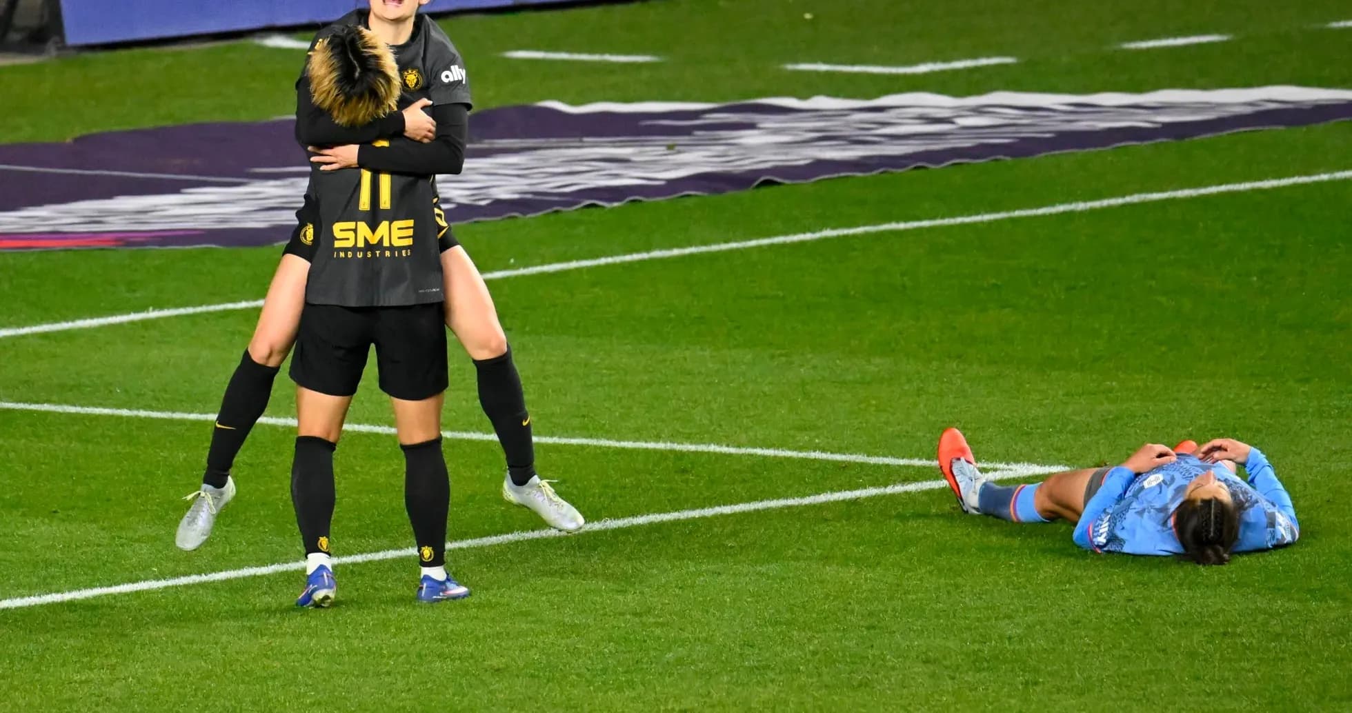 Jugadoras celebrando en partido de fútbol femenino