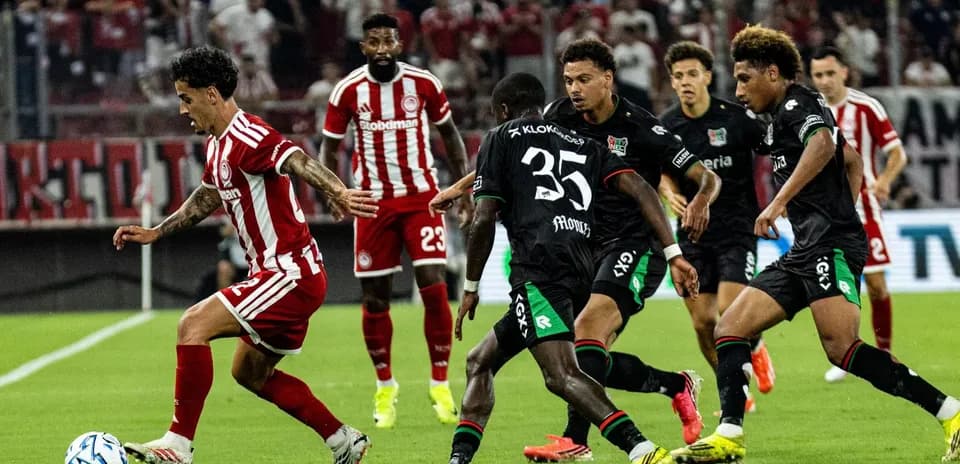 Jugador de Olympiakos Piraeus driblando a defensores de NEC