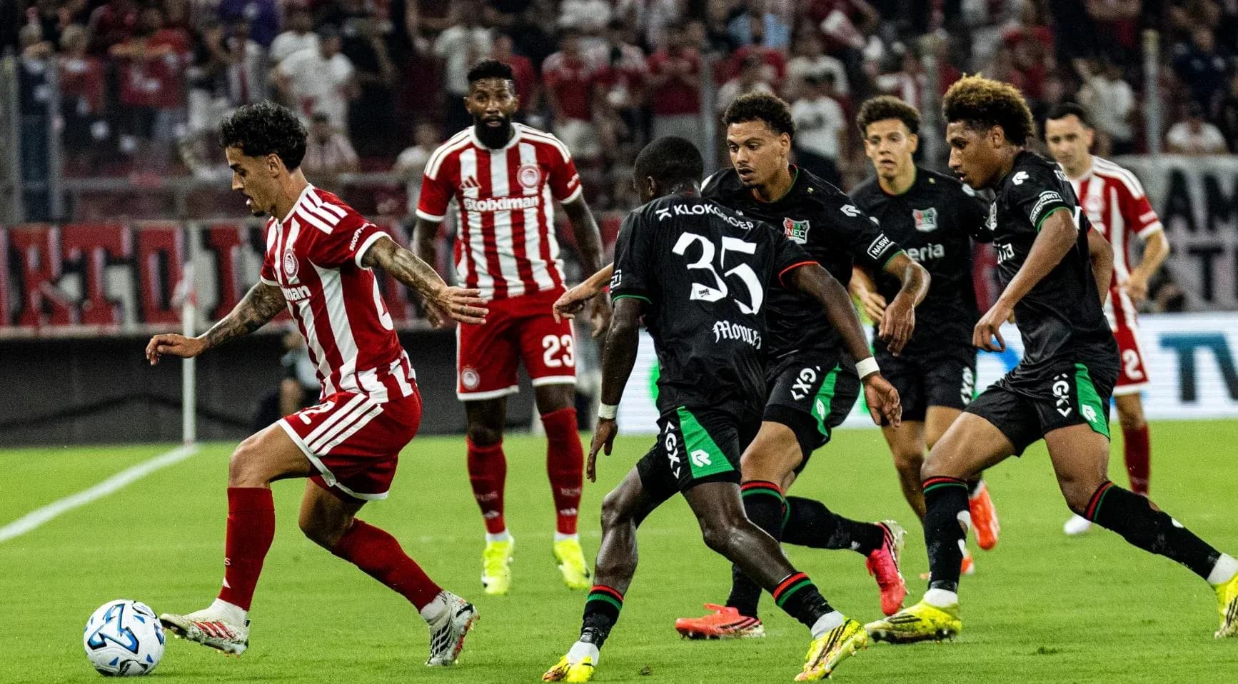 Jugador de Olympiakos Piraeus driblando a defensores de NEC