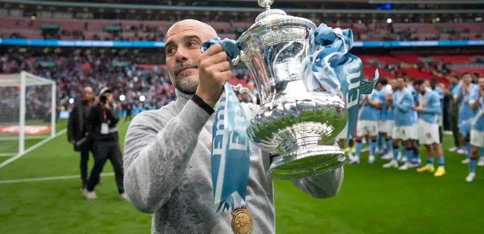 Entrenador sostiene trofeo en el campo de Wembley