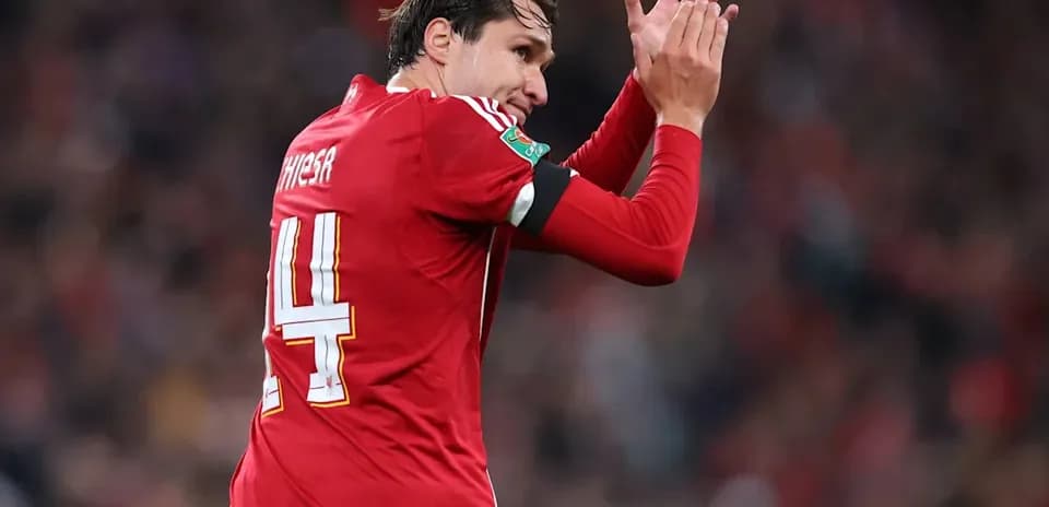Jugador aplaudiendo con camiseta roja en el campo