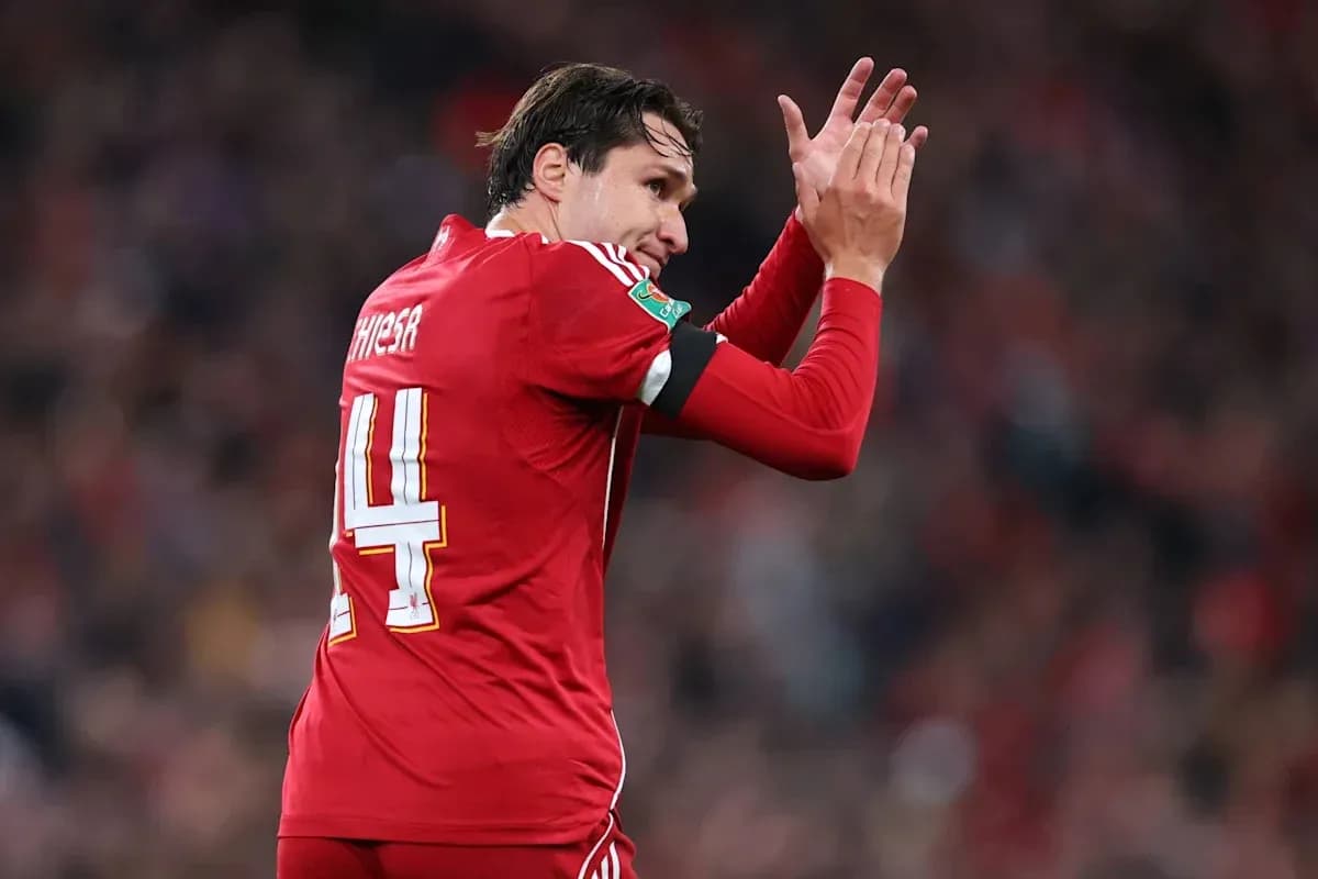 Jugador aplaudiendo con camiseta roja en el campo