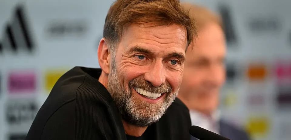 Entrenador sonriendo en rueda de prensa