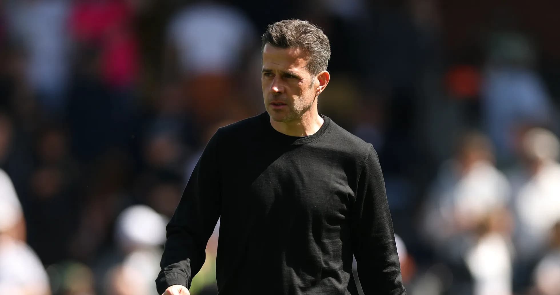 Entrenador caminando por el campo durante el partido