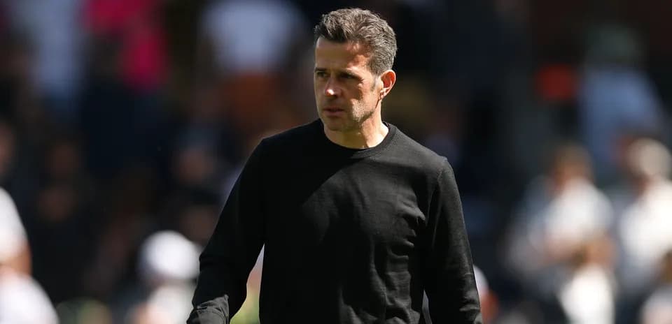 Entrenador caminando por el campo durante el partido