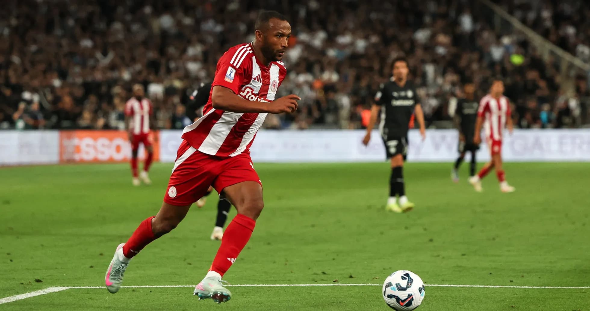 Jugador de Olympiacos corriendo tras el balón en partido