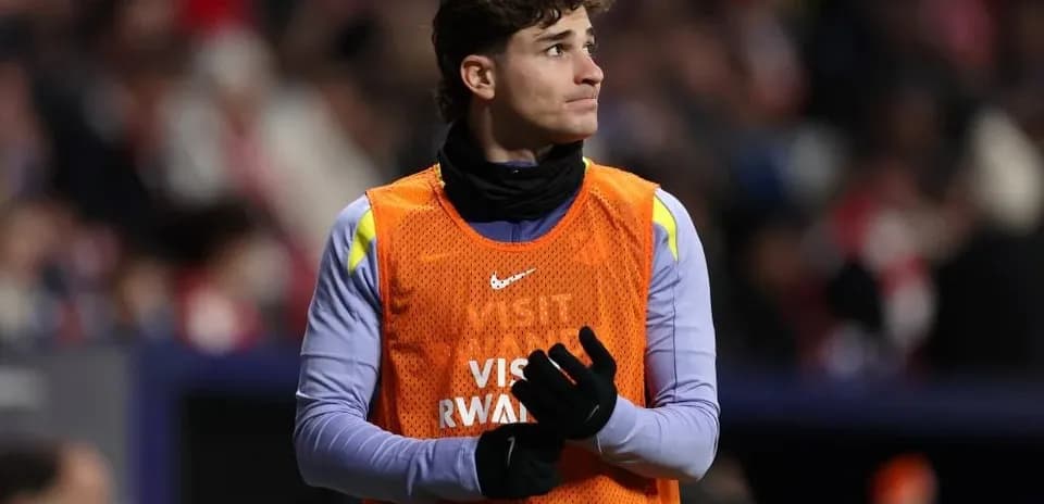 Jugador en el banquillo con chaleco naranja
