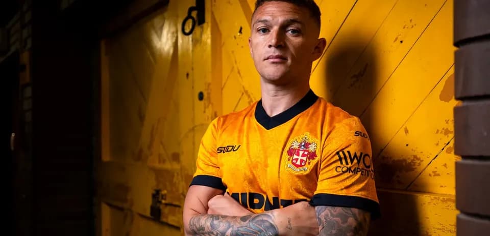 Jugador posando con camiseta de equipo en fondo amarillo