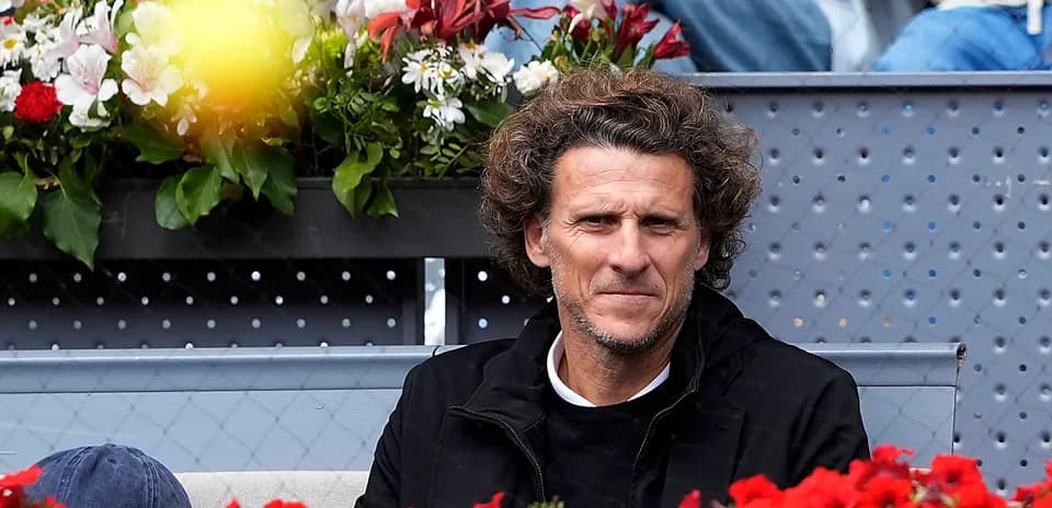 Hombre sentado en un palco rodeado de flores