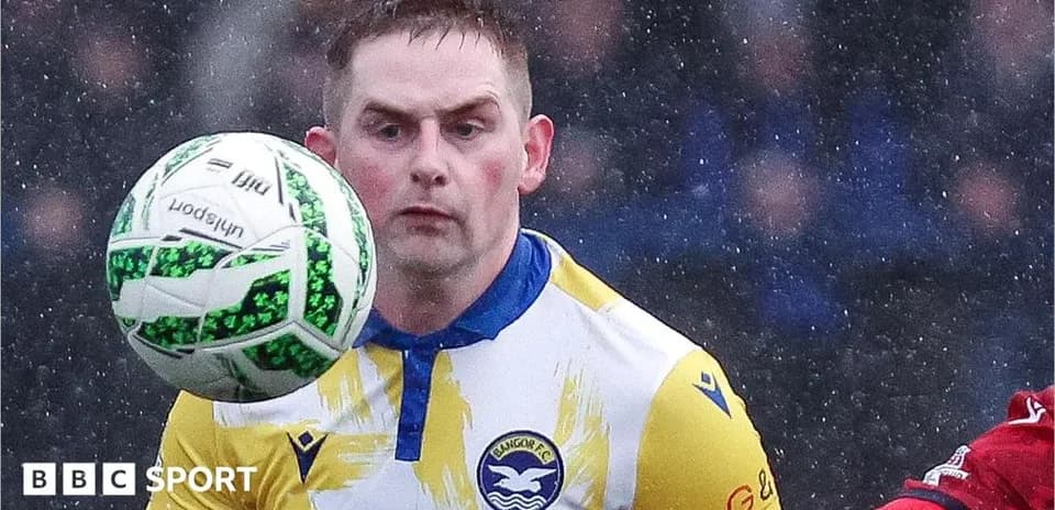 Jugador de Bangor FC controlando el balón en lluvia