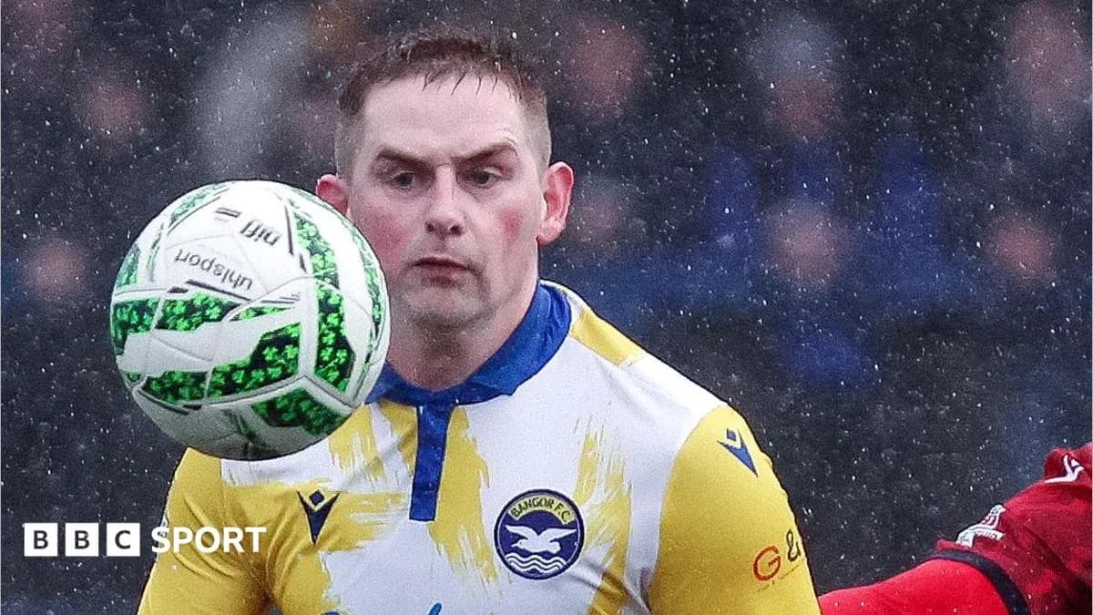 Jugador de Bangor FC controlando el balón en lluvia