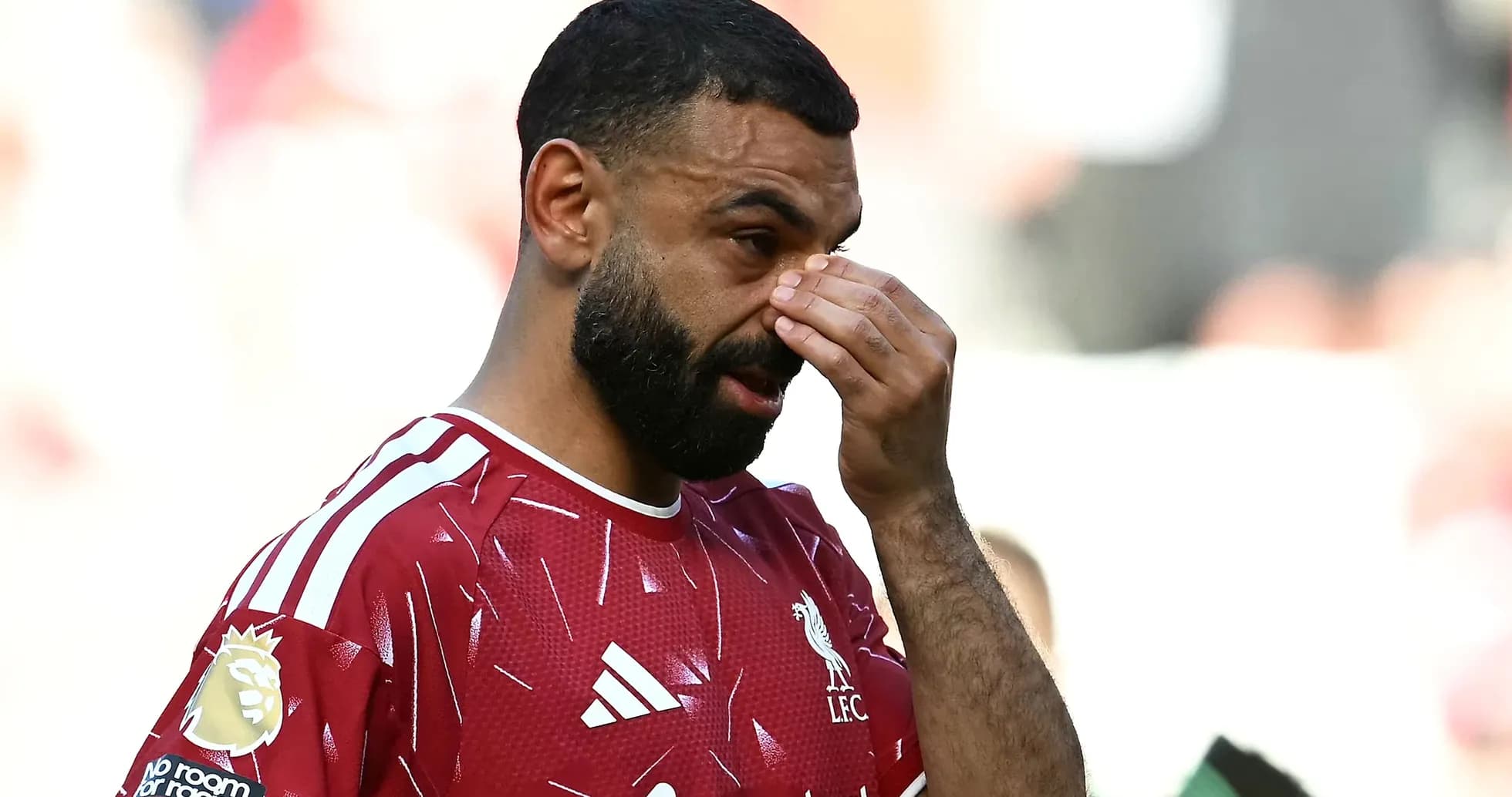 Jugador de Liverpool tocándose la cara durante el partido