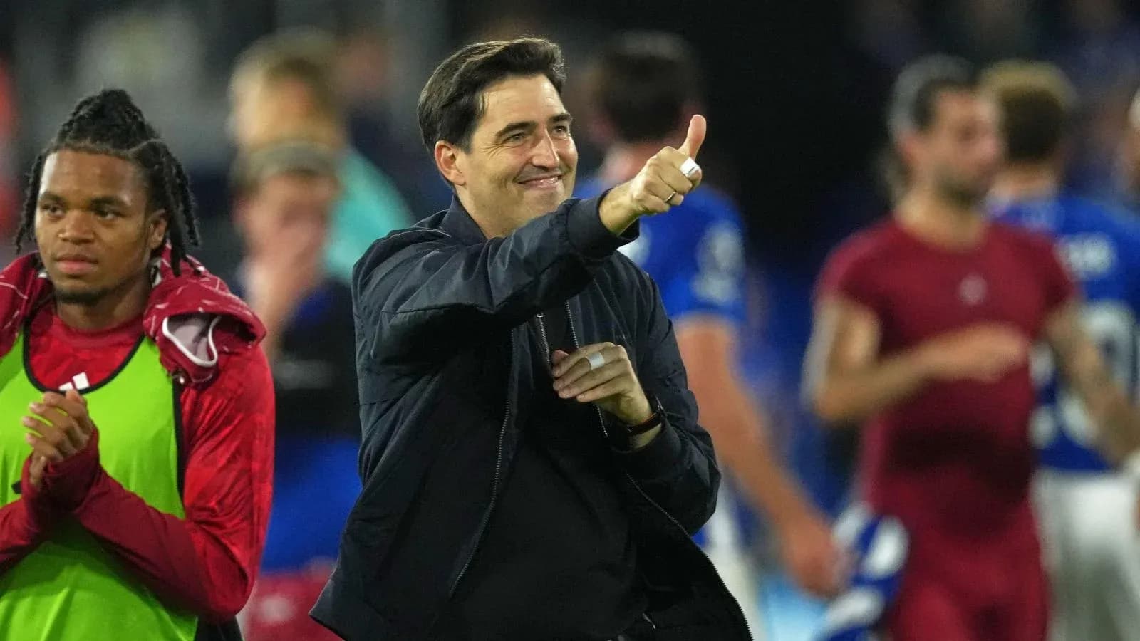 Entrenador sonriente aplaudiendo después del partido