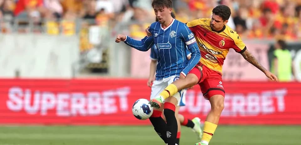 Jugador de Jagiellonia desafiando a jugador de Rangers