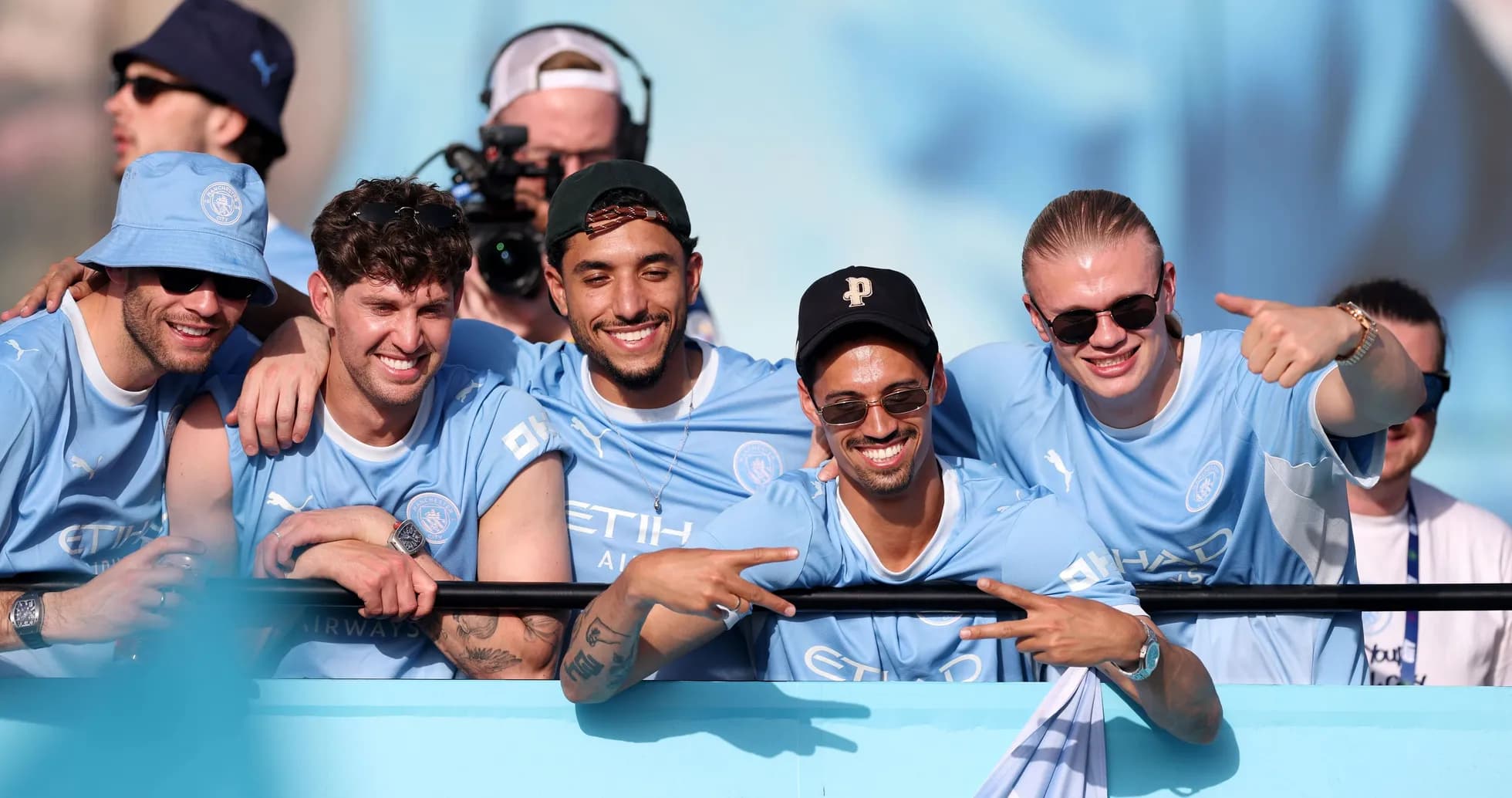 Cinco aficionados de Manchester City posando sonrientes Cinco aficionados de Manchester City posando sonrientes