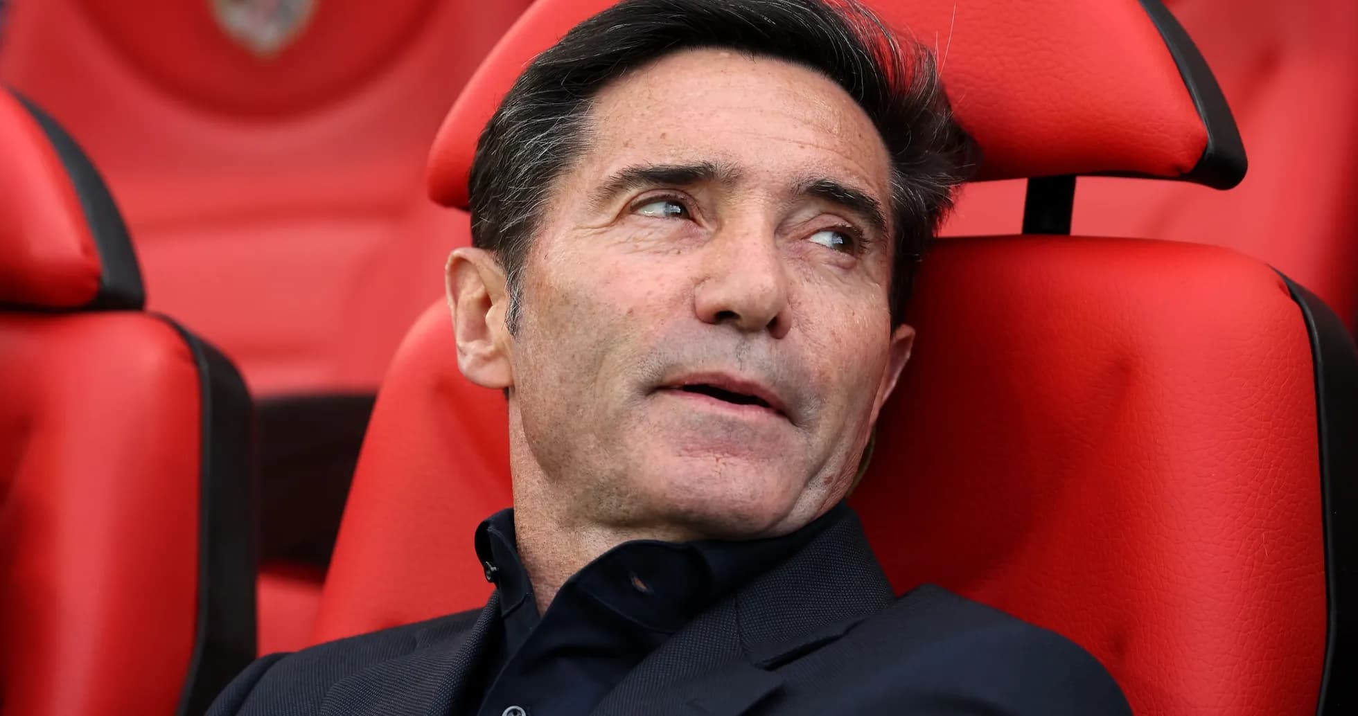 Entrenador sentado en banquillo con fondo rojo Entrenador sentado en banquillo con fondo rojo