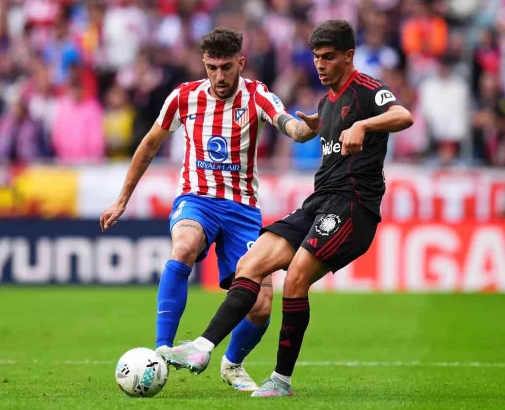 Dos jugadores compitiendo por el balón Dos jugadores compitiendo por el balón
