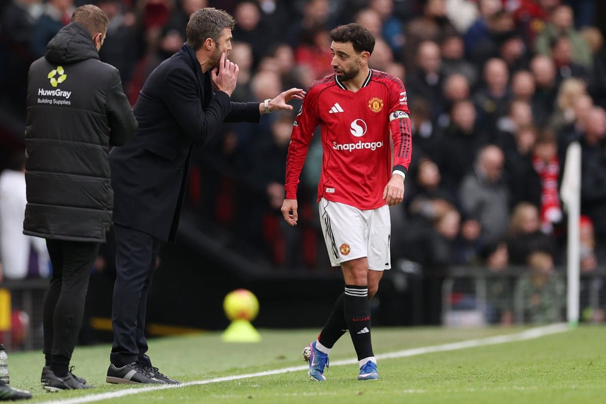 Entrenador instruyendo a jugador de Manchester United Entrenador instruyendo a jugador de Manchester United