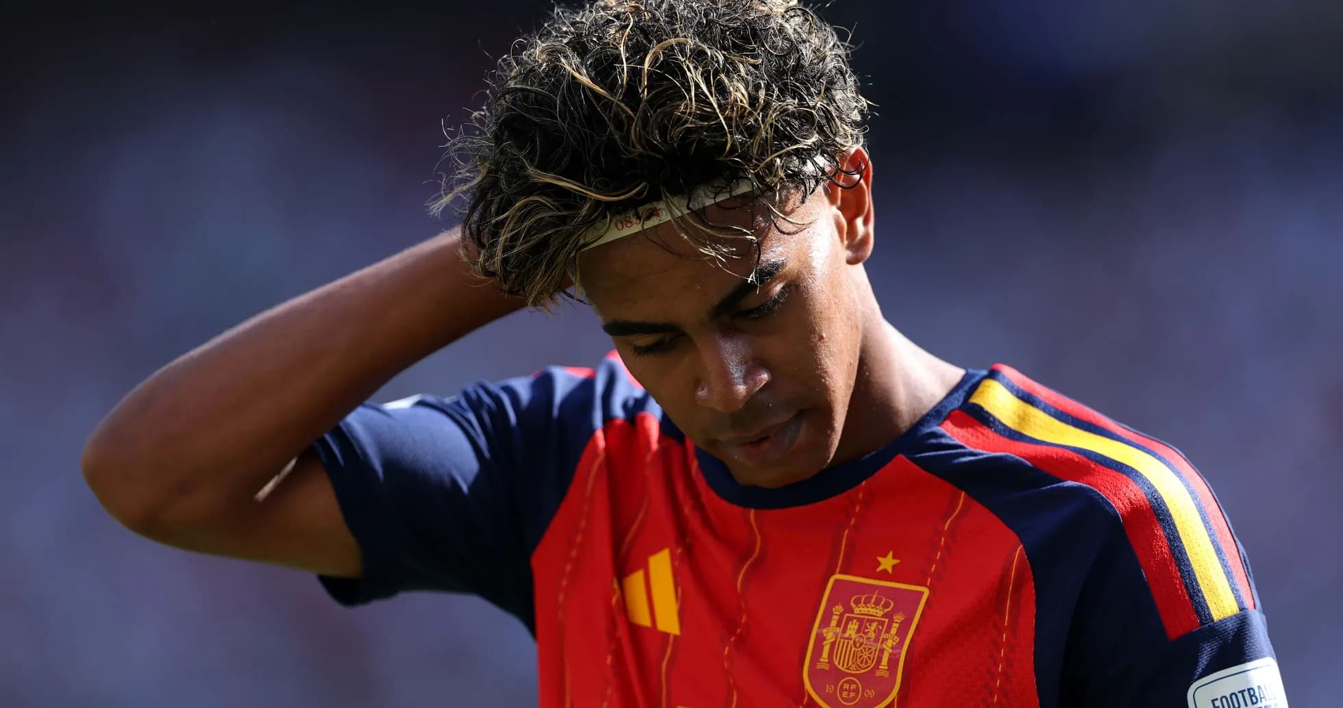Jugador de España con camiseta roja, cabeza agachada Jugador de España con camiseta roja, cabeza agachada
