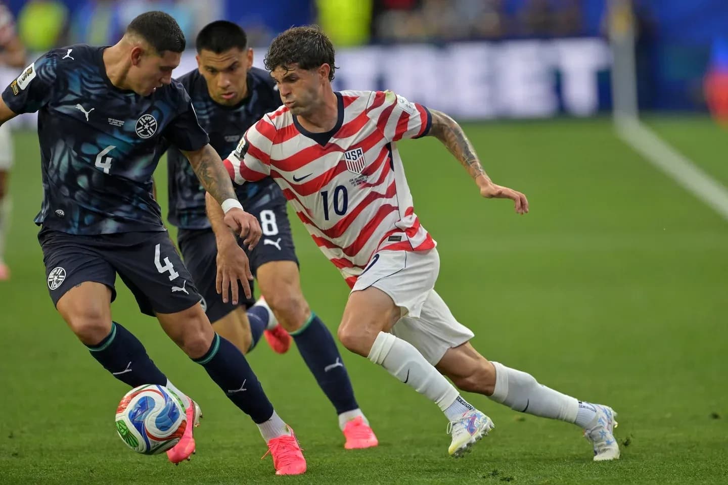 Christian Pulisic dribbling past defenders during match Christian Pulisic dribbling past defenders during match