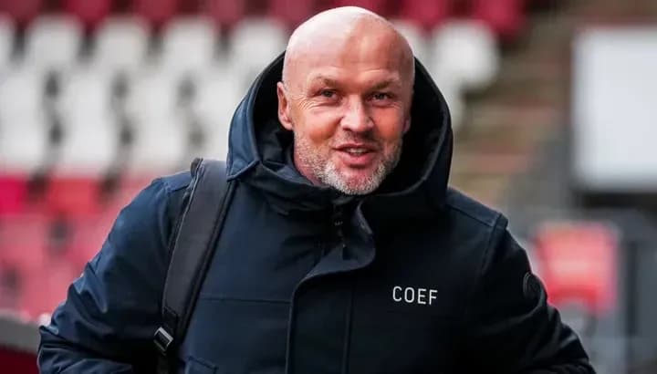 Hombre con chaqueta negra sonriendo en estadio Hombre con chaqueta negra sonriendo en estadio