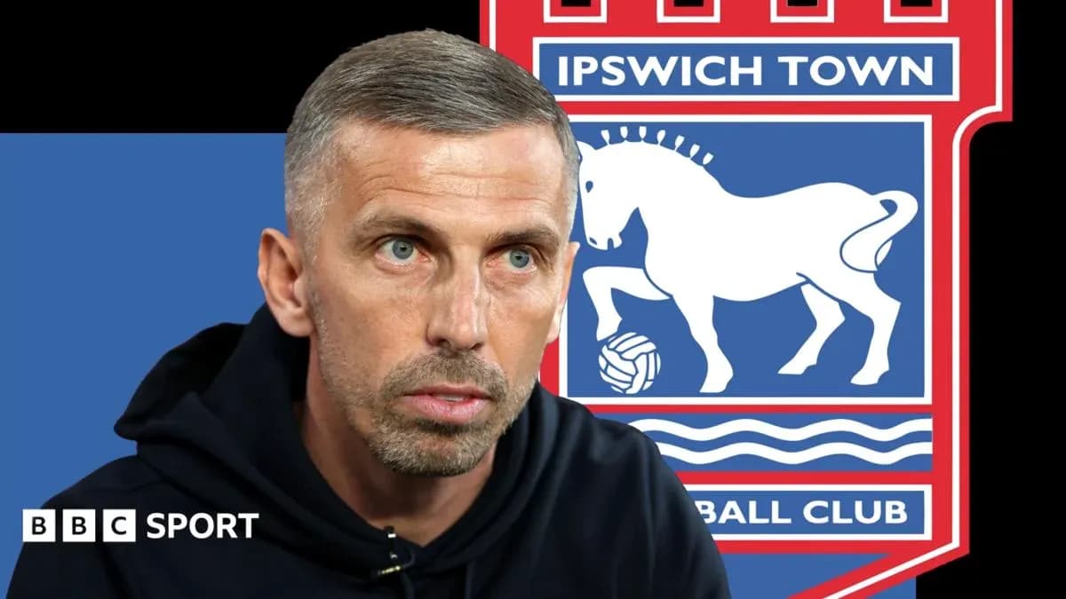 Entrenador hablando frente al escudo de Ipswich Town Entrenador hablando frente al escudo de Ipswich Town