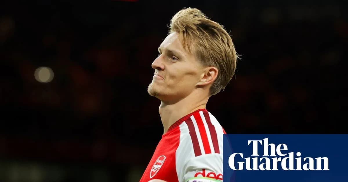 Jugador de Arsenal mirando hacia un lado en el campo Jugador de Arsenal mirando hacia un lado en el campo