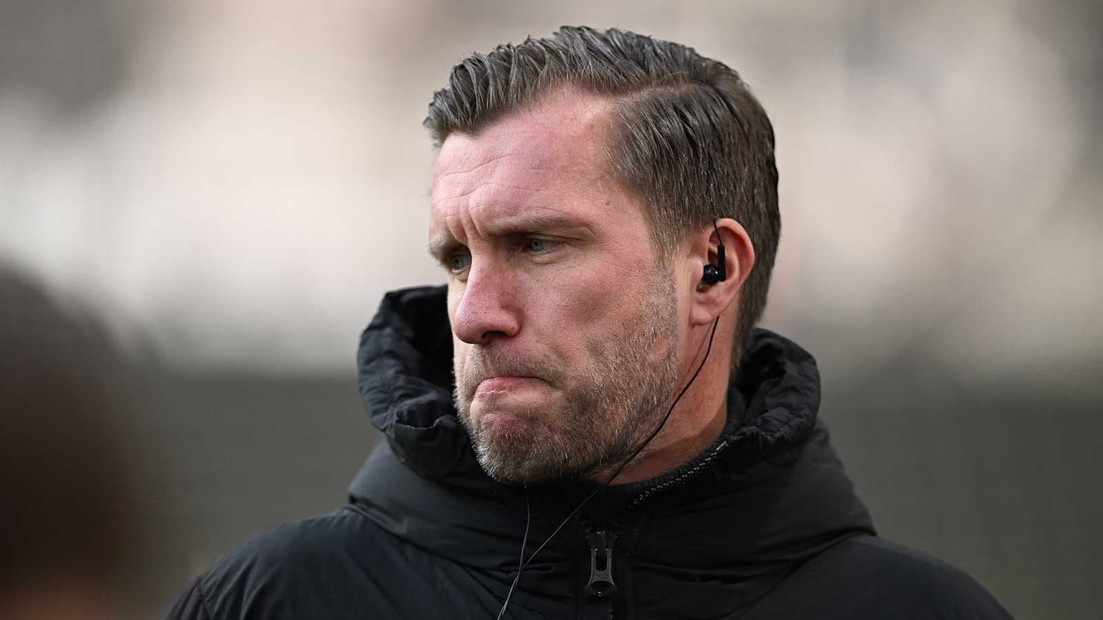 Entrenador con auriculares en campo de entrenamiento Entrenador con auriculares en campo de entrenamiento