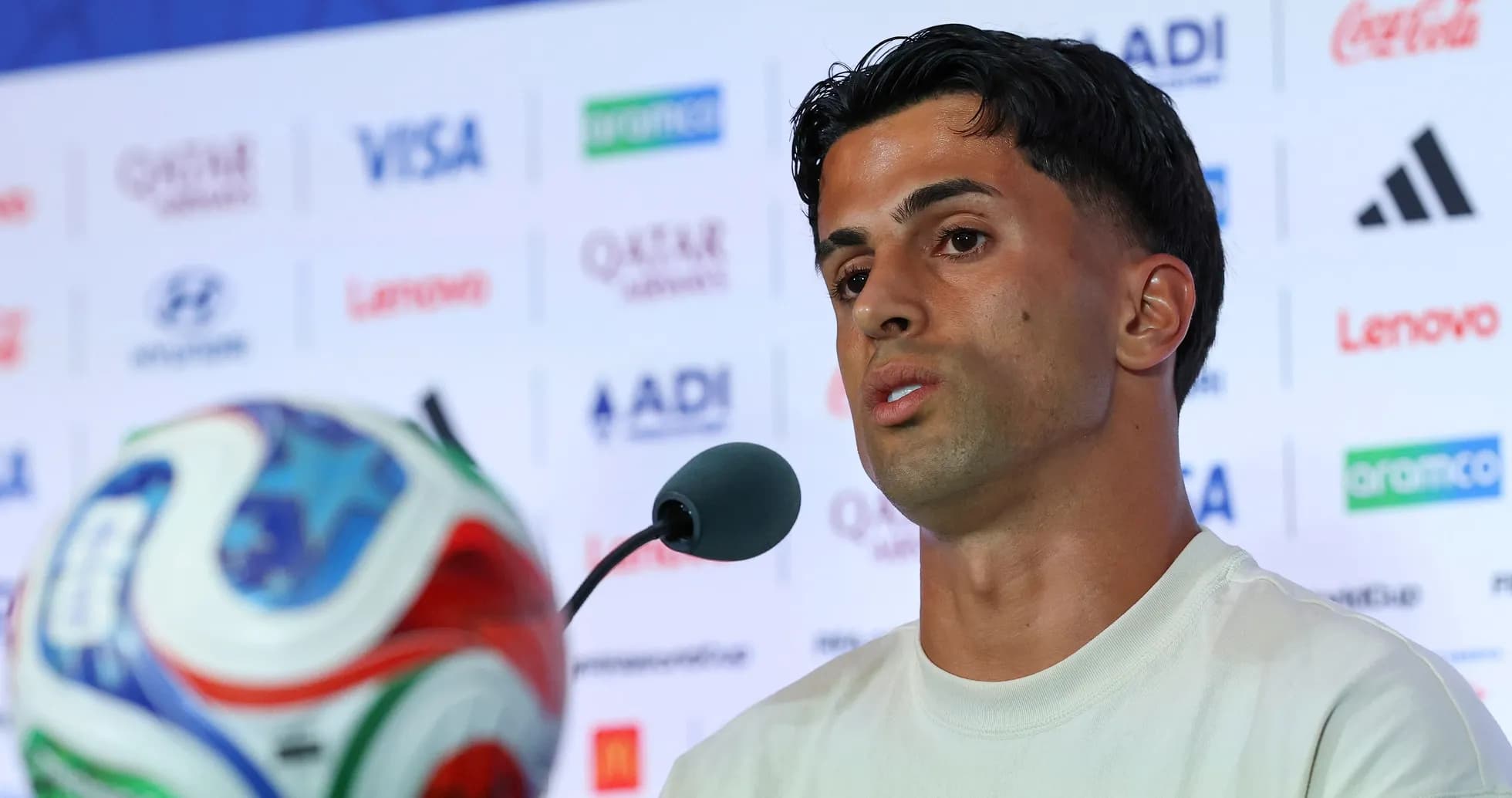 Jugador hablando en conferencia de prensa con balón Jugador hablando en conferencia de prensa con balón