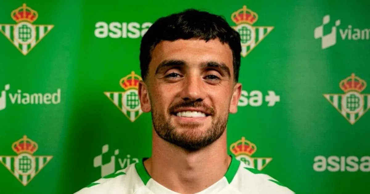 Jugador sonriendo frente a fondo del club Real Betis Jugador sonriendo frente a fondo del club Real Betis